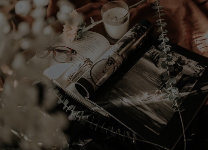 A cozy scene with a book, glasses, and flowers on a blanket. Perfect for reading and relaxing outdoors